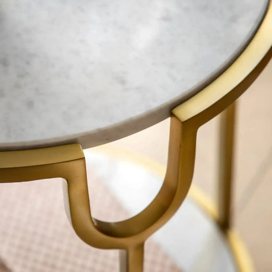 Round marble table with gold metal frame on a blurred background