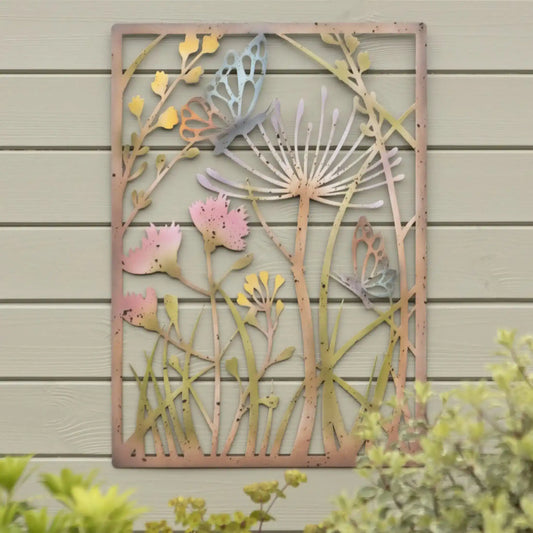 Decorative metal wall art with floral and butterfly design on a wooden wall.