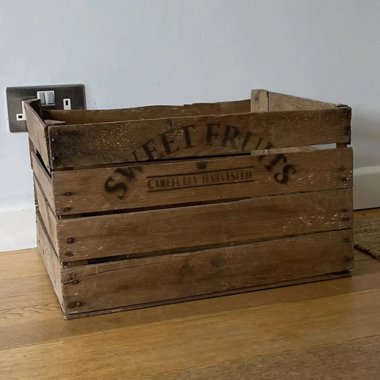 Wooden crate with 'Sweet Fruits' branding on a wooden floor.