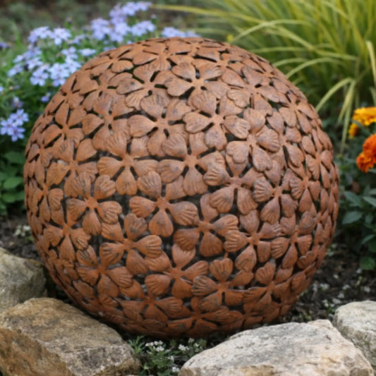 Decorative brown spherical object with floral pattern on a garden background
