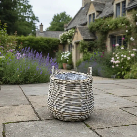 Wicker basket on a stone patio with a garden and house in the background