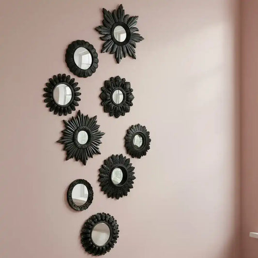 Set of black decorative mirrors with starburst designs on a white background