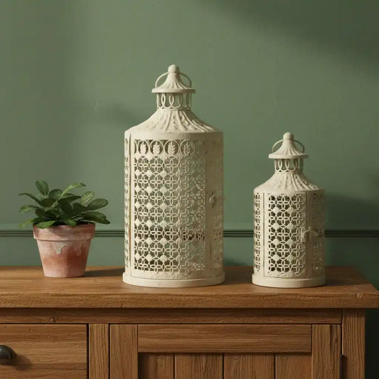 Two decorative lanterns on a wooden surface with a green wall background