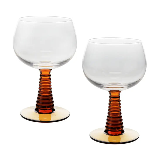 Two clear stemmed glasses with ribbed amber-brown stems and round clear bases, shown on a white background.