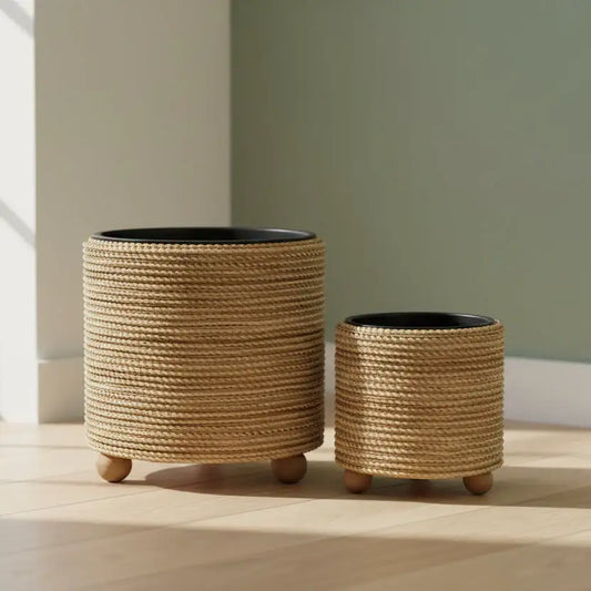 Two woven planters on wheels against a neutral wall.