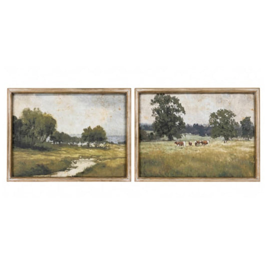 A pair of framed landscape paintings side by side, depicting grassy fields, trees, and a small stream, with cows visible in the right painting.