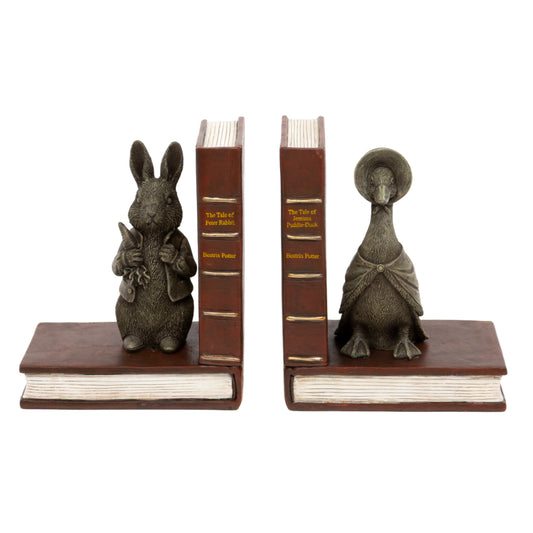 A pair of decorative bookends shaped like old book spines, with a small rabbit figurine on the left and a duck figurine on the right, both mounted on brown faux-leather bases against a plain white background.