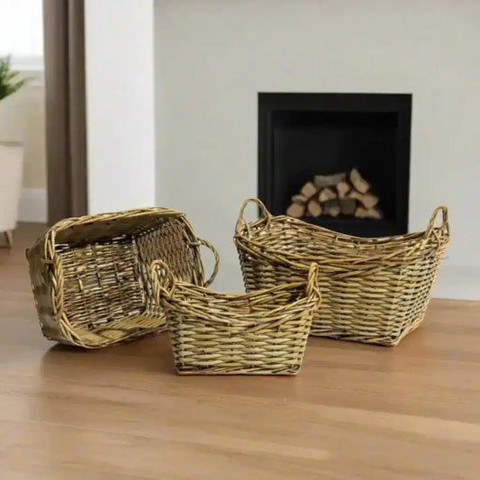 Three wicker baskets of different sizes on a wooden floor with a fireplace in the background.