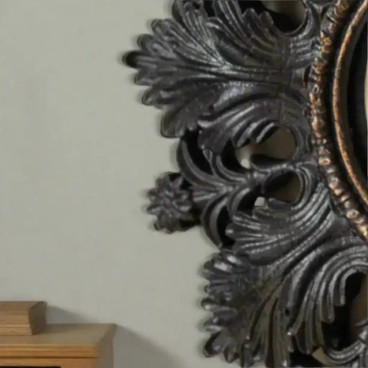 Decorative metal wall piece with intricate designs on a beige background