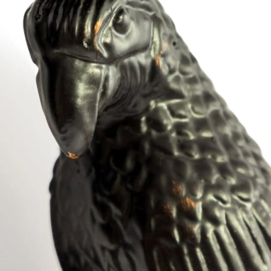 Close-up of a black parrot figurine on a white background