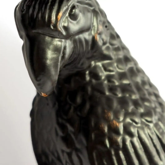 Close-up of a black parrot figurine on a white background