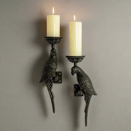 Pair of parrot-shaped wall sconces with candles on a white background