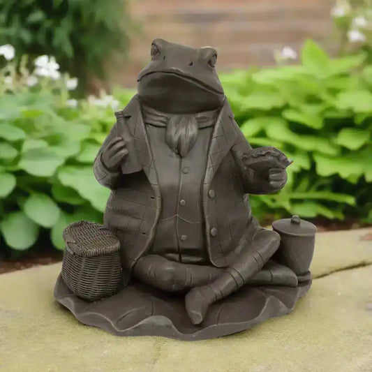 Statue of a frog in a suit holding a tea set on a white background