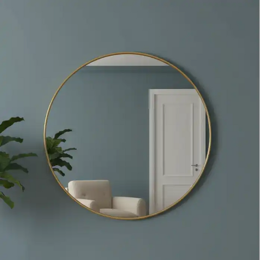 Round gold-framed mirror on a dark teal wall with a white door and plant in the reflection.