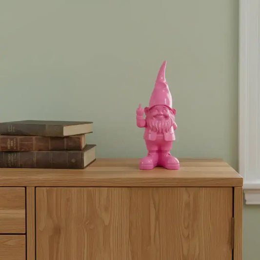 Pink gnome figurine on a wooden surface with books against a green wall.