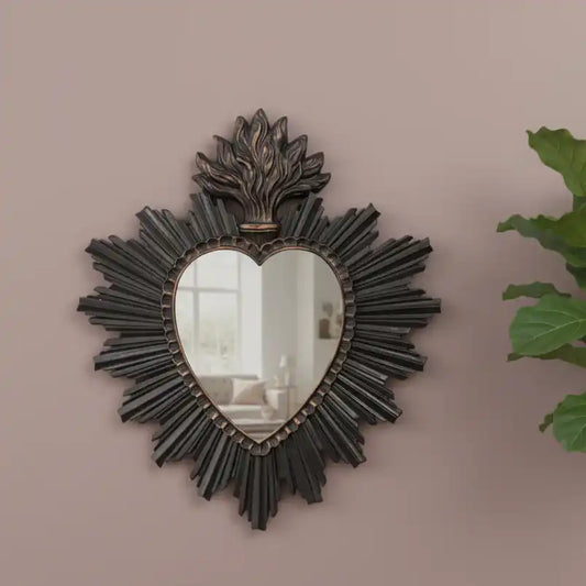 Decorative heart-shaped mirror with intricate design on a beige wall.
