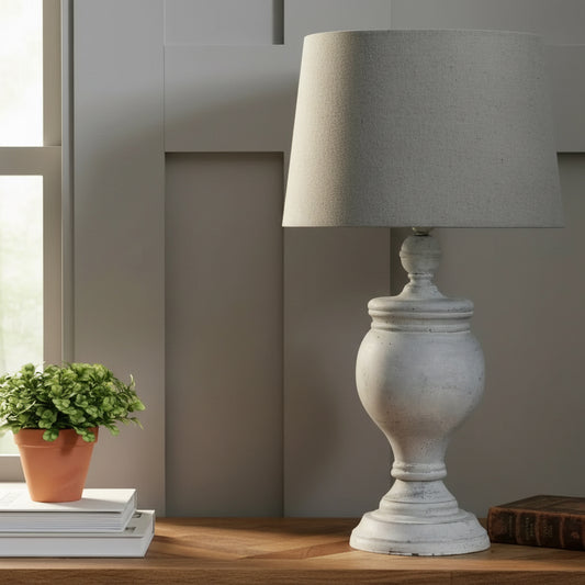 Decorative lamp and framed picture on a wooden surface with a neutral background