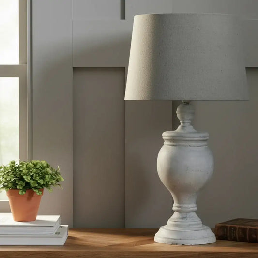 Decorative lamp and framed picture on a wooden surface with a neutral background