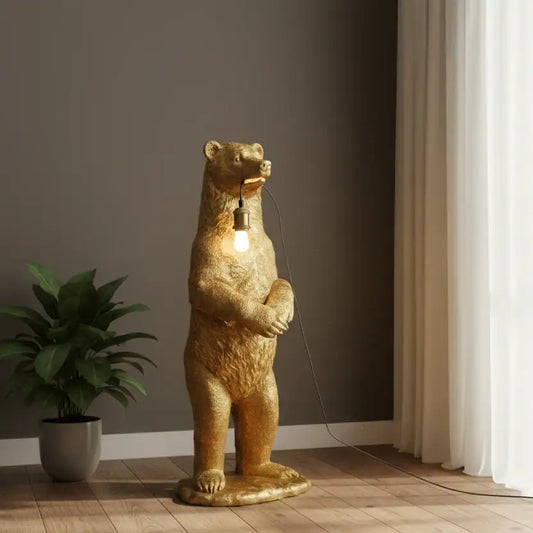 Gold bear-shaped floor lamp in a room with a plant and curtains.
