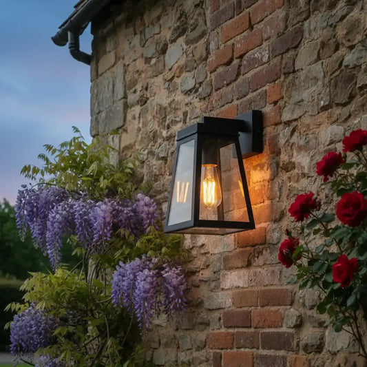 Black outdoor wall light fixture on a wooden wall with blurred natural background