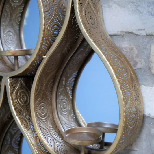 Decorative metal wall art with intricate patterns on a textured wall background