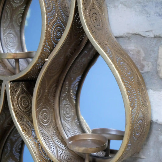 Decorative metal wall art with intricate patterns on a textured wall background