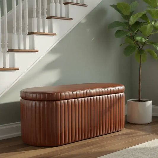 Brown leather ottoman in a room with a staircase and a potted plant.