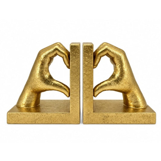 A pair of gold-finished bookends shaped like hands forming a heart shape, set against a plain white background.