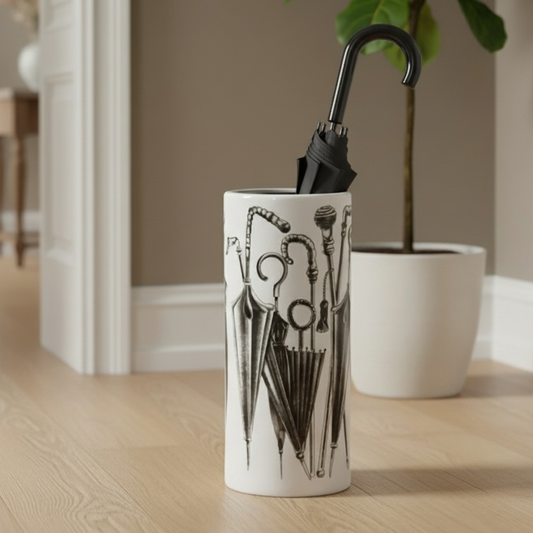 Decorative vase with black abstract design on a wooden floor in a room with a plant and furniture.
