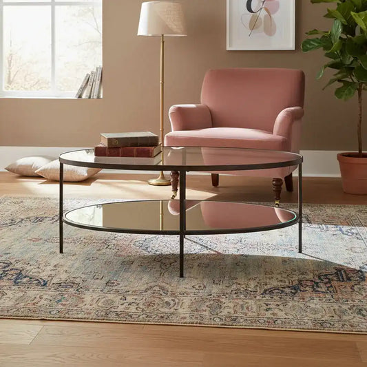 Living room with a pink armchair, glass coffee table, and decorative elements.