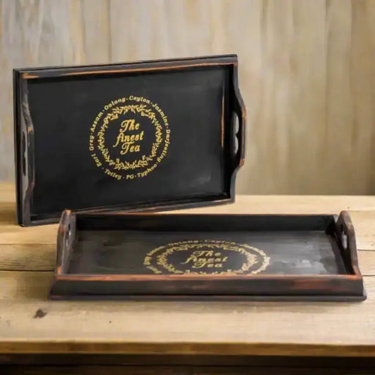 Two black trays with gold text on a white background