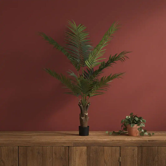 Potted plant on a wooden surface with a red-brown wall background