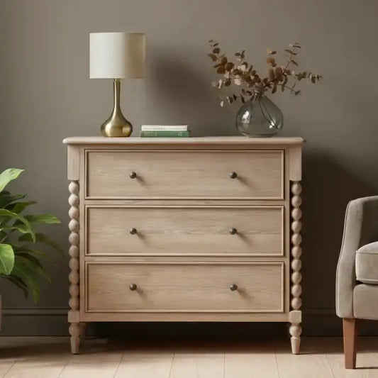 Wooden dresser with a lamp and plant in a room setting
