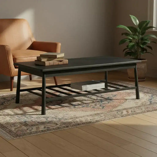 Black metal coffee table with decorative items in a room with a plant and patterned rug.