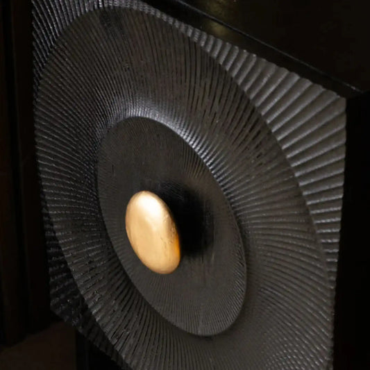 Close-up of a speaker with a gold ball in the center