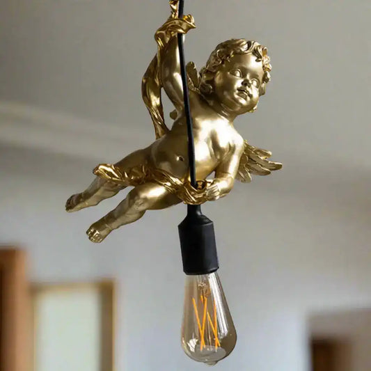 Gold cherub figure with a light bulb inside against a neutral background
