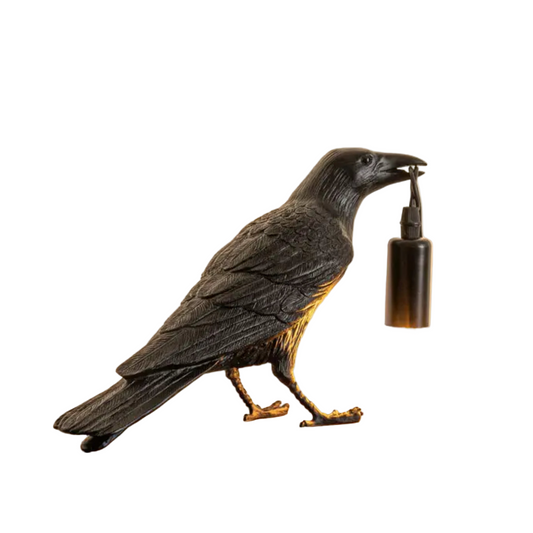 Statue of a crow holding a bottle on a white background