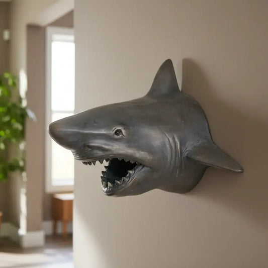 Shark head wall decoration in a room with a plant and window.