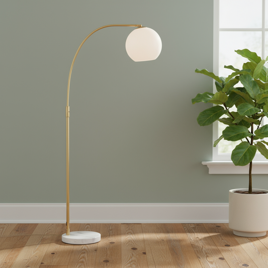 Modern floor lamp with a spherical shade next to a potted plant in a room with a green wall and wooden floor.