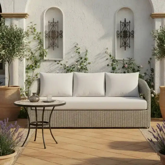 Outdoor patio setting with a wicker sofa, small table, and decorative elements.