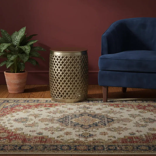 Decorative rug with a blue chair and patterned side table against a red wall.