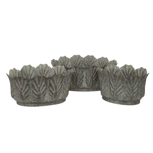 Set of four decorative metal planters with leaf pattern on a white background