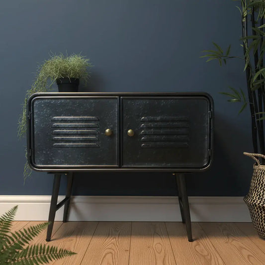Black metal cabinet with gold handles against a dark blue wall with plants.