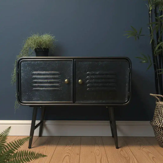 Black metal cabinet with gold handles against a dark blue wall with plants.