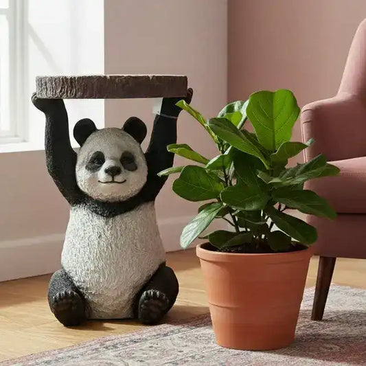 Panda-shaped stool next to a potted plant in a room with a pink chair.