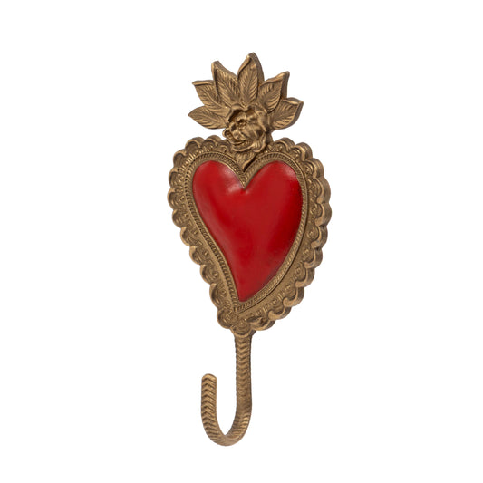 An ornate antique-style brass heart-shaped wall hook featuring a red enamel heart in the center, a sculpted face at the top, and a hanging hook below, shown on a plain white background.