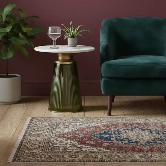 Small round table with a glass top, green ribbed base, and decorative items on a white background