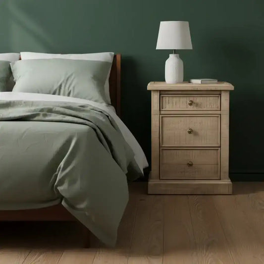 Bedroom with a wooden nightstand and lamp against a dark green wall.
