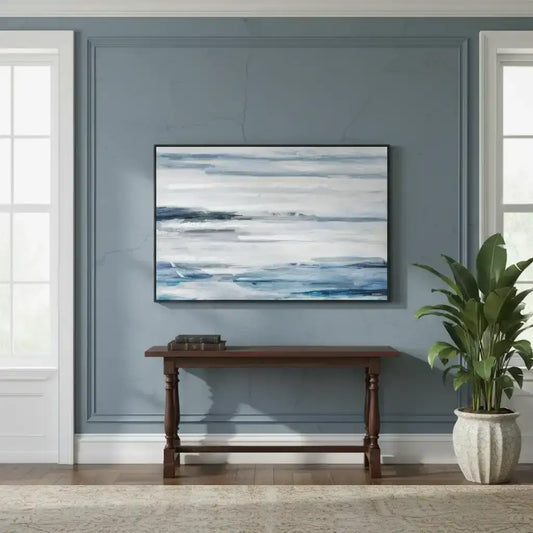 Abstract painting on a wall above a wooden console table with a plant in a room.