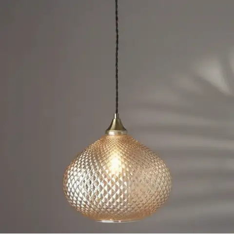 Decorative pendant light with textured glass shade on a dark background